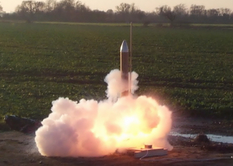 A rocket launching from a launch pad. The microcud, a NASRA built rocket.