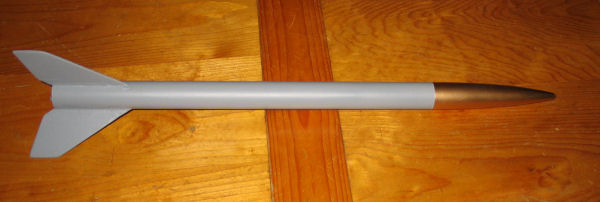 Picture of the rocket body which has been primed with grey primer and a gold nosecone